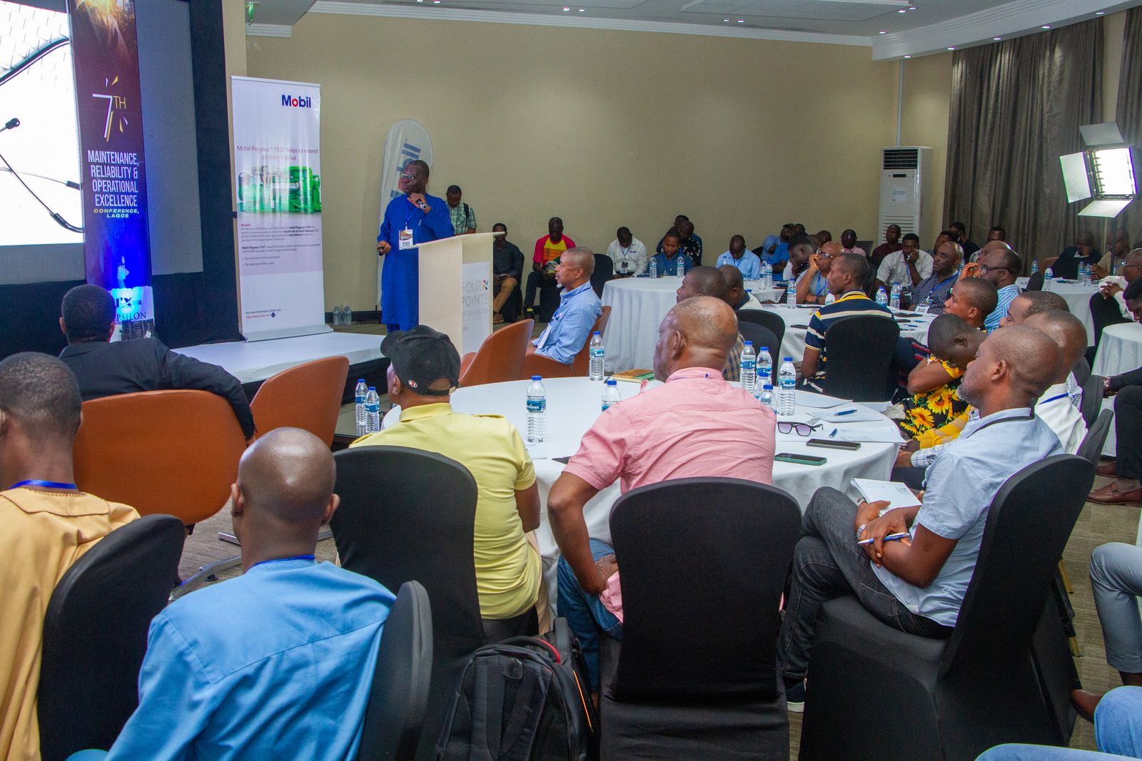 A full conference room listening to a speaker at a previous edition